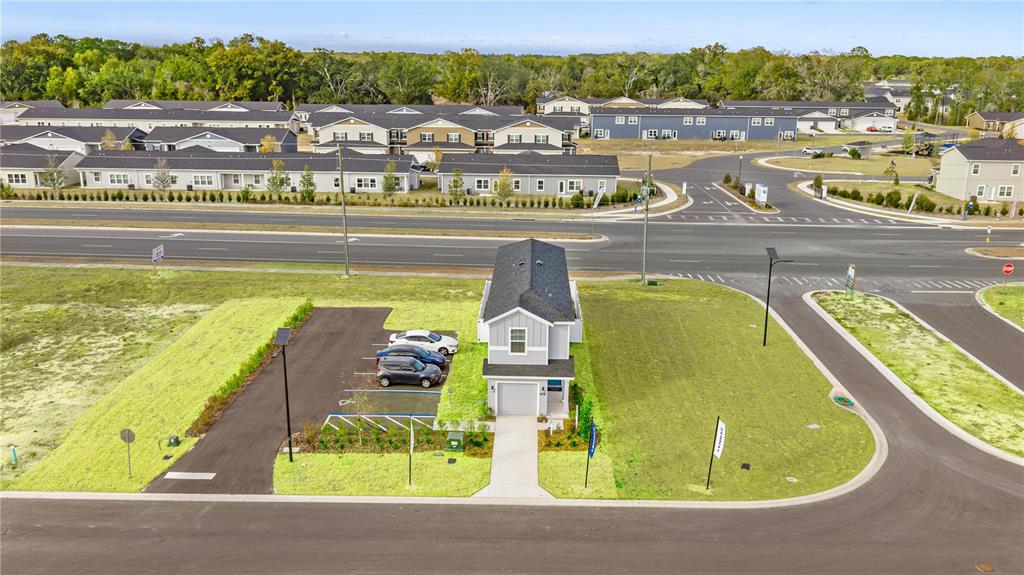 An aerial view shows a single-family home with a parking lot and surrounding residential neighborhood — 9199 SW 91ST COURT, OCALA, FL