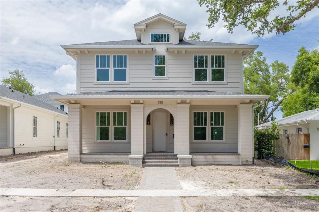 An aerial view of a two-story house with light siding, a covered porch, and unfinished landscaping — 125 24TH AVENUE SE, ST PETERSBURG, FL