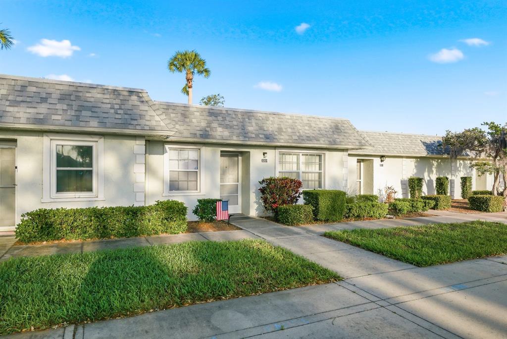 A single-story residential building with a gray shingled roof, light-colored stucco, and manicured landscaping — 3309 TROPHY BOULEVARD, NEW PORT RICHEY, FL