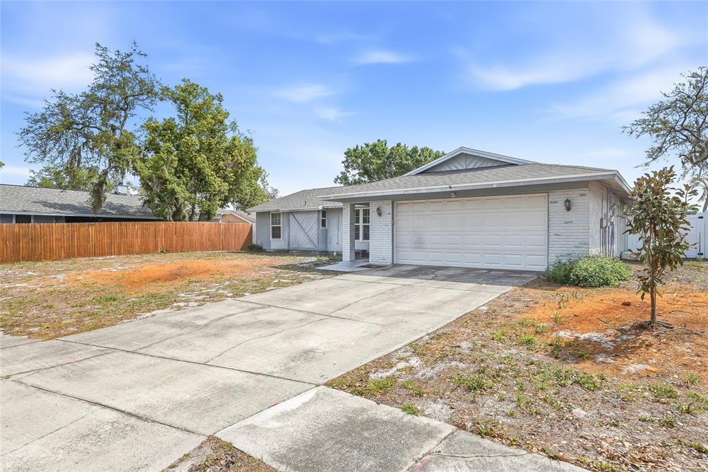 A single-story house with a white brick facade, a two-car garage, and a concrete driveway — 4104 FALLON COURT, BRANDON, FL