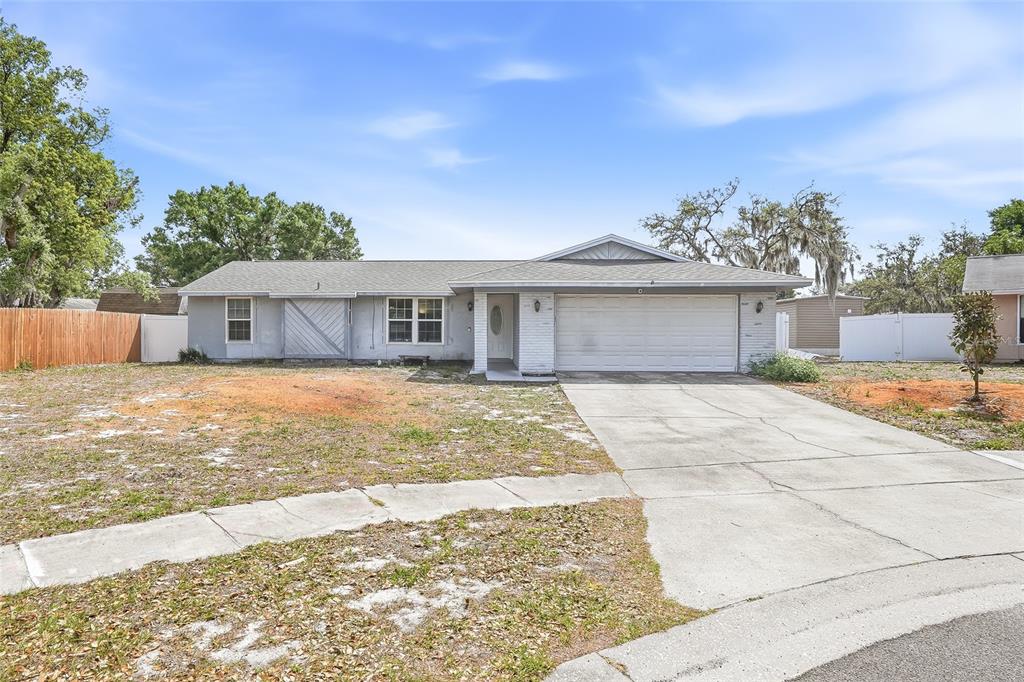 A single-story house with a gray exterior, a two-car garage, and a concrete driveway — 4104 FALLON COURT, BRANDON, FL