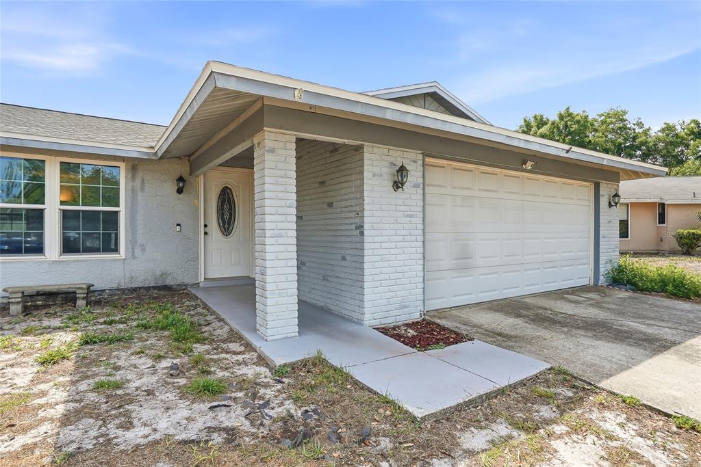 A single-story house exterior features a white brick pillar, a garage, and a front entrance — 4104 FALLON COURT, BRANDON, FL