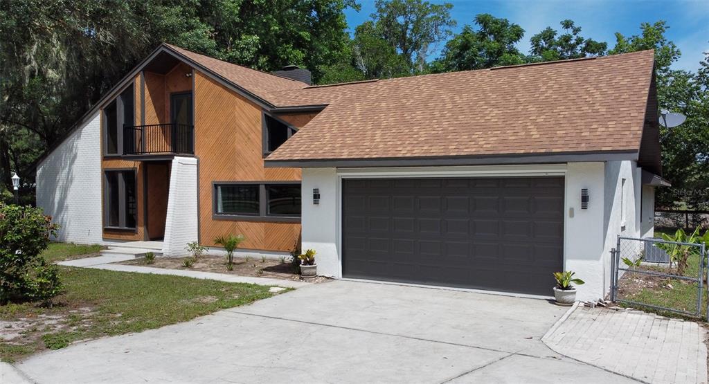A two-story house with white brick, wood siding, and a two-car garage — 507 E HIGHWAY 318, CITRA, FL