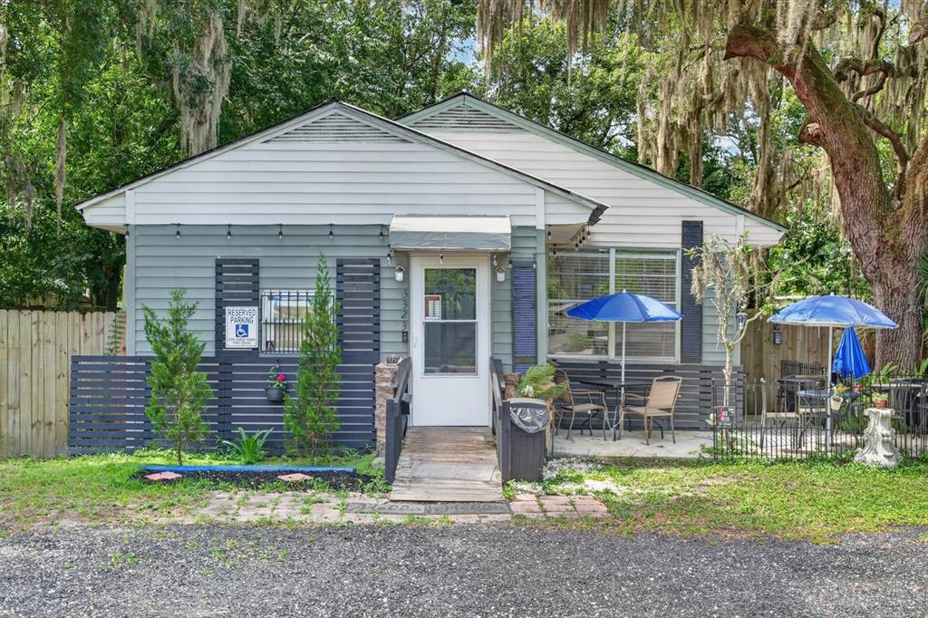 A single-story building with gray siding, a wooden ramp, and outdoor patio seating areas — 3323 SAINT JOHNS AVENUE, PALATKA, FL