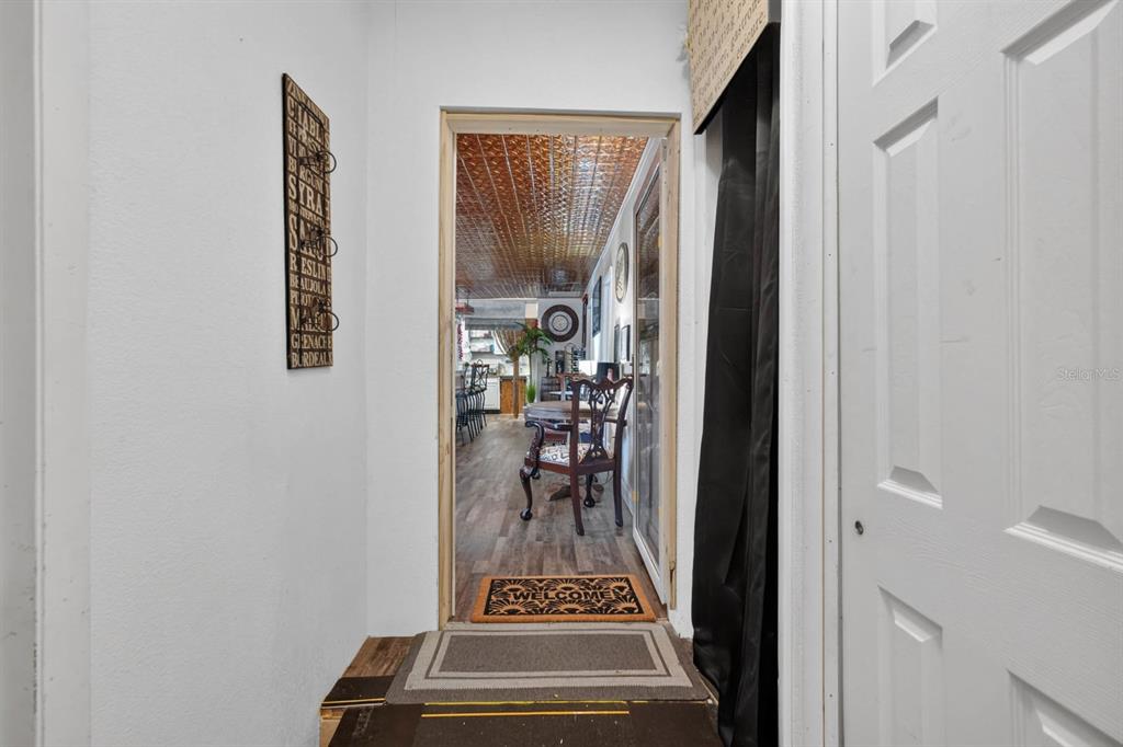 A view through a doorway into a room with a metallic ceiling and wood flooring — 3323 SAINT JOHNS AVENUE, PALATKA, FL
