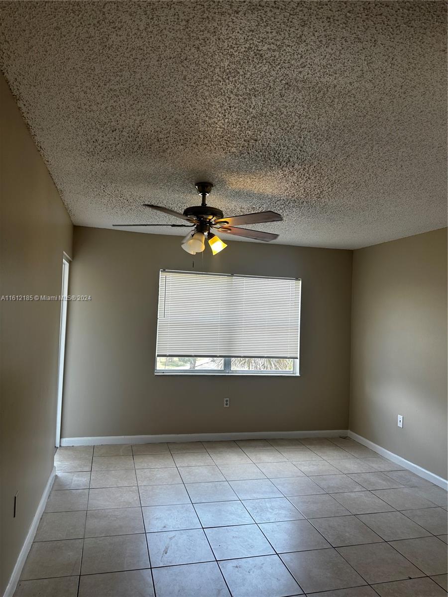 An empty room features beige walls, a tiled floor, and a ceiling fan — 4324 NW 9th Ave # 3A, Deerfield Beach FL 33064, DEERFIELD BEACH, FL