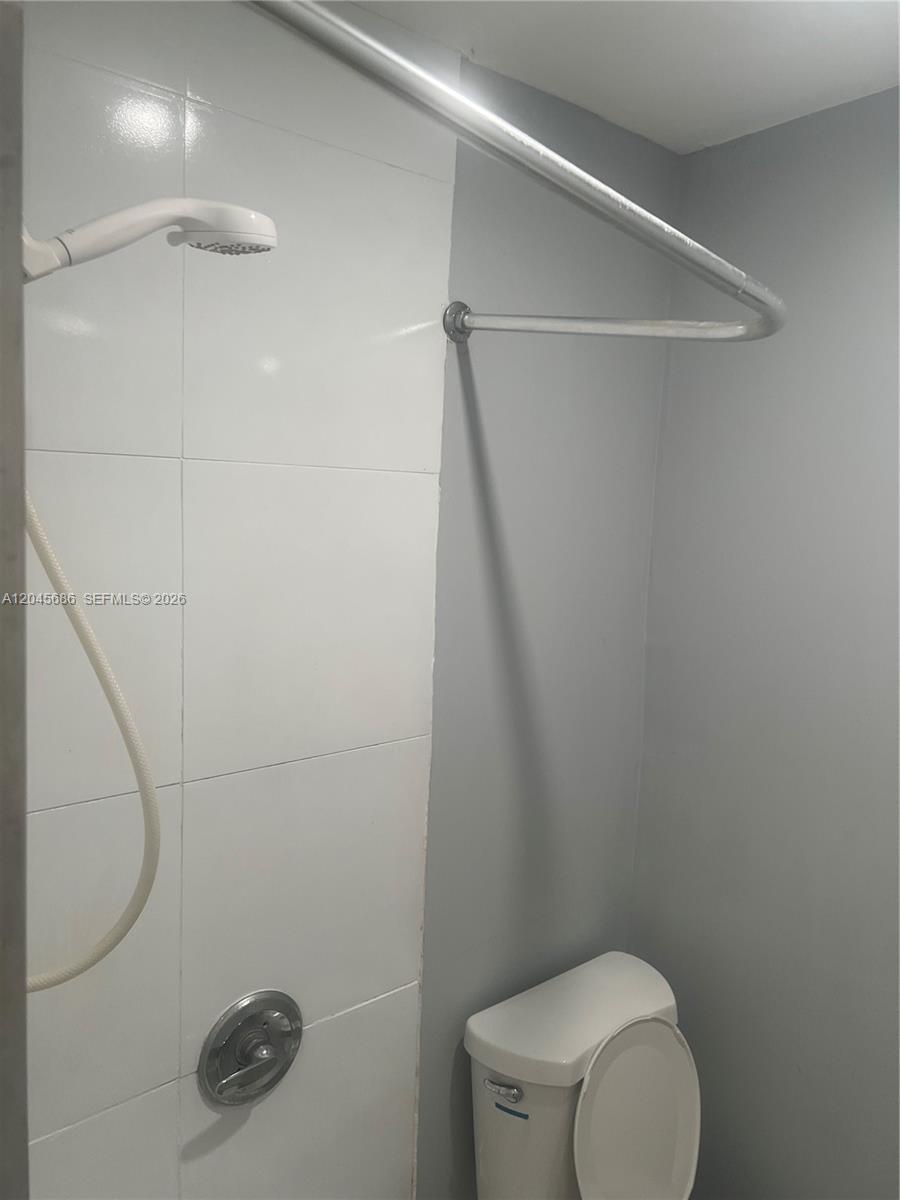 A bathroom features a white tiled shower wall, a handheld showerhead, and a toilet — 2118 N 19th Ave # 4, Hollywood FL 33020, HOLLYWOOD, FL