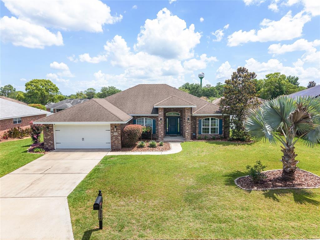 A dining room features a wooden table and hutch, a chandelier, and light wood flooring — 6746 SE 12TH PLACE, OCALA, FL