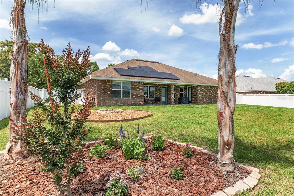 A room with green walls, floor-to-ceiling wooden bookshelves, a television, and a glass coffee table — 6746 SE 12TH PLACE, OCALA, FL