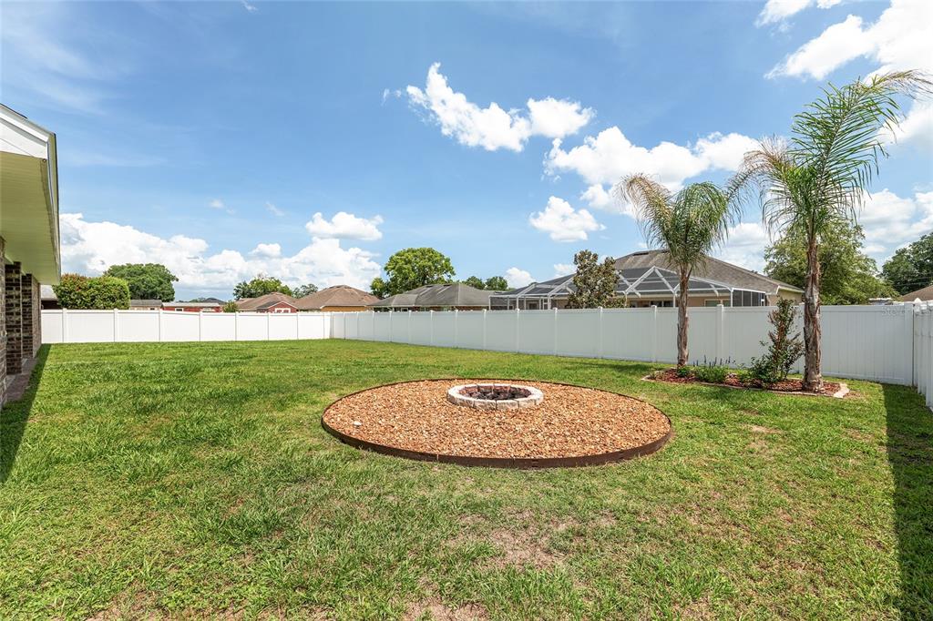 A green-walled room with a couch, glass coffee table, musical instruments, and a ceiling fan — 6746 SE 12TH PLACE, OCALA, FL