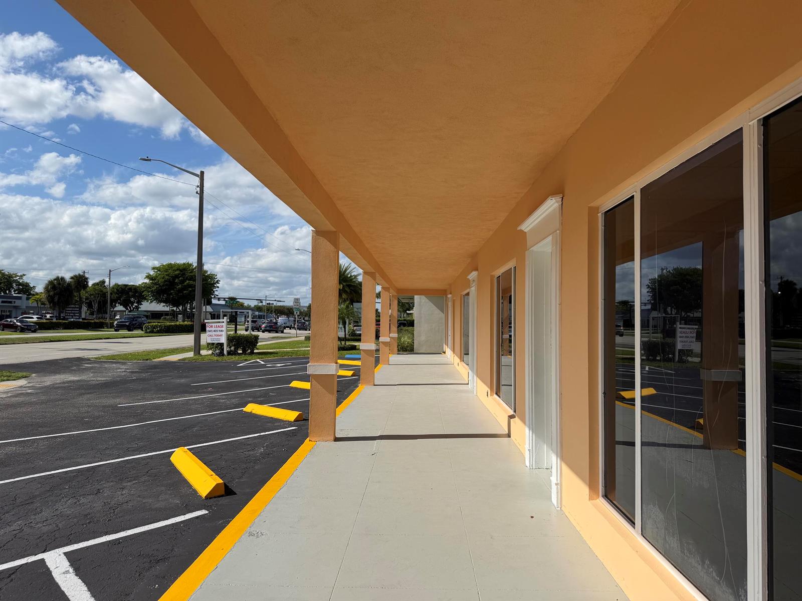 A covered exterior walkway runs along a peach-colored building with large glass storefront windows — 3060 N Federal Highway, Boca Raton FL 33431, BOCA RATON, FL