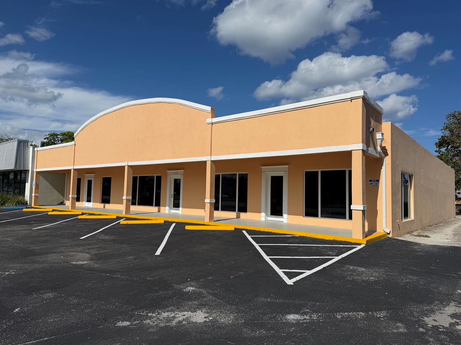 A peach-colored commercial building with a curved roofline and a paved parking lot — 3060 N Federal Highway, Boca Raton FL 33431, BOCA RATON, FL