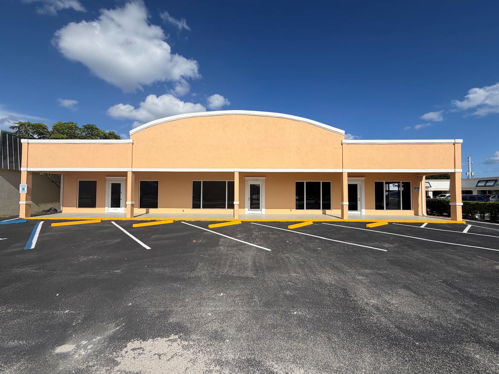 A single-story commercial building with a peach-colored facade and a large parking lot — 3060 N Federal Highway, Boca Raton FL 33431, BOCA RATON, FL