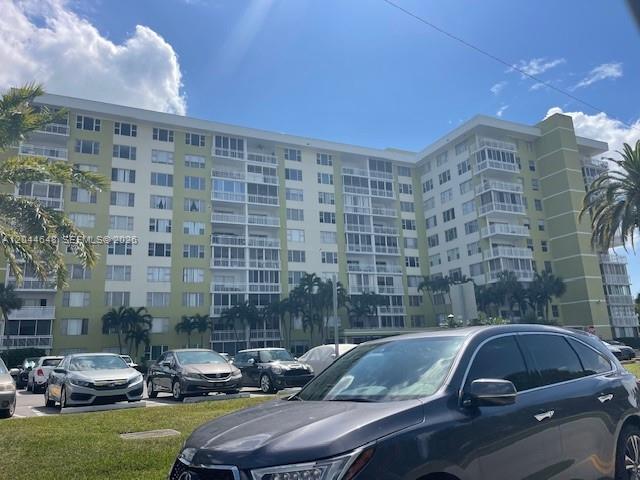 A multi-story apartment building with balconies stands behind a parking lot filled with cars — 4400 Hillcrest Dr # 701B, Hollywood FL 33021, HOLLYWOOD, FL