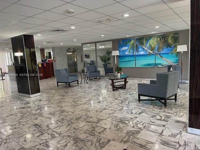 A lobby features marble floors, gray armchairs, a glass coffee table, and a tropical wall mural — 4400 Hillcrest Dr # 701B, Hollywood FL 33021, HOLLYWOOD, FL