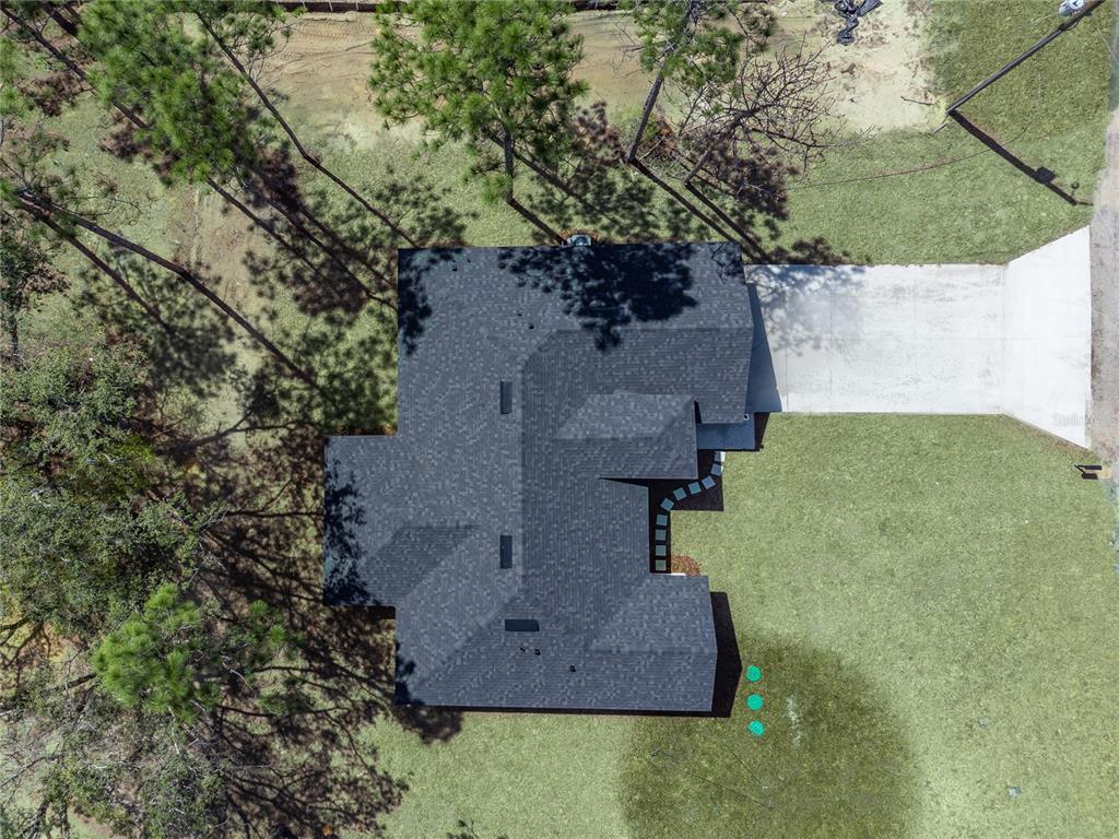 An aerial view shows a house with a dark shingled roof and a concrete driveway — 9609 N VAUGHN DRIVE, CITRUS SPRINGS, FL