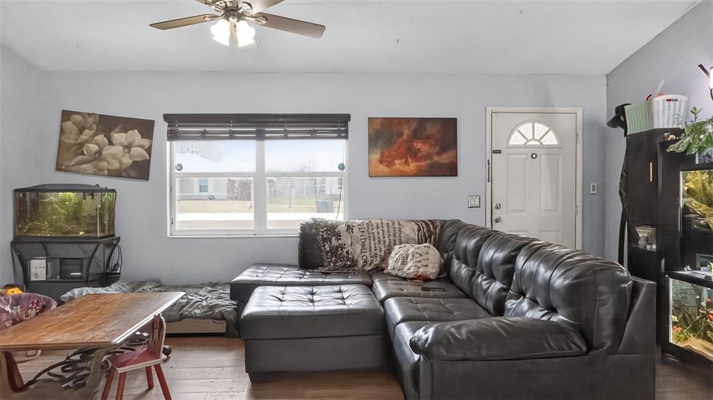 A living room features a black sectional sofa, a wooden table, and two fish tanks — 24 PECAN COURSE LOOP, OCALA, FL