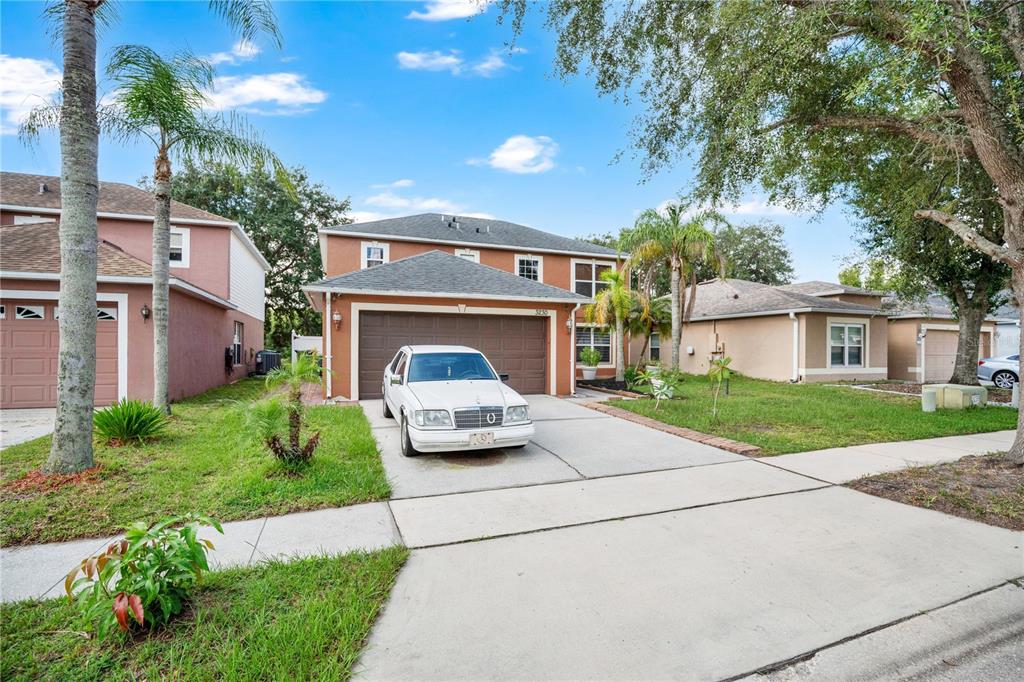 A two-story suburban house with a white sedan parked in the driveway — 3230 ERSKINE DRIVE, ORLANDO, FL