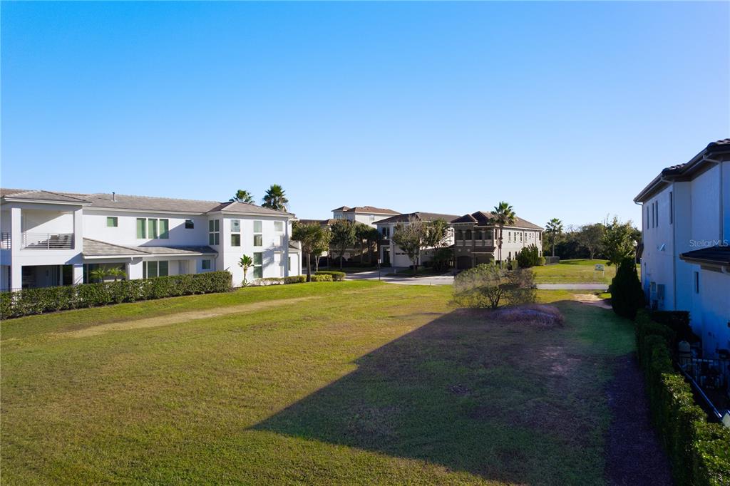 An aerial view of a golf course fairway surrounded by residential homes and palm trees — 1188 CASTLE PINES COURT, REUNION, FL