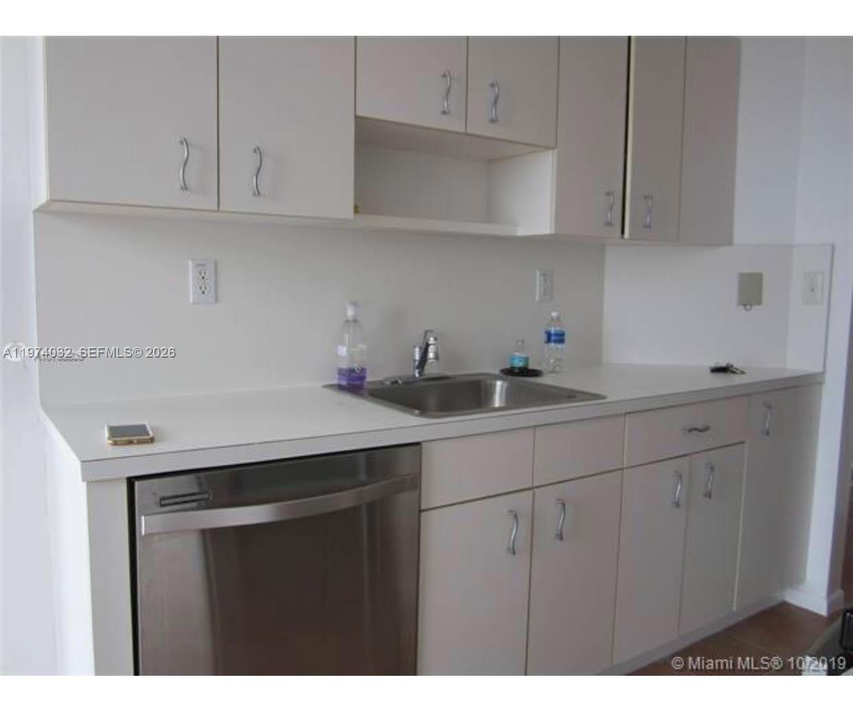 A kitchen features white cabinets, a stainless steel dishwasher, and a stainless steel sink — 1688 West Ave # 1107, Miami Beach FL 33139, MIAMI BEACH, FL
