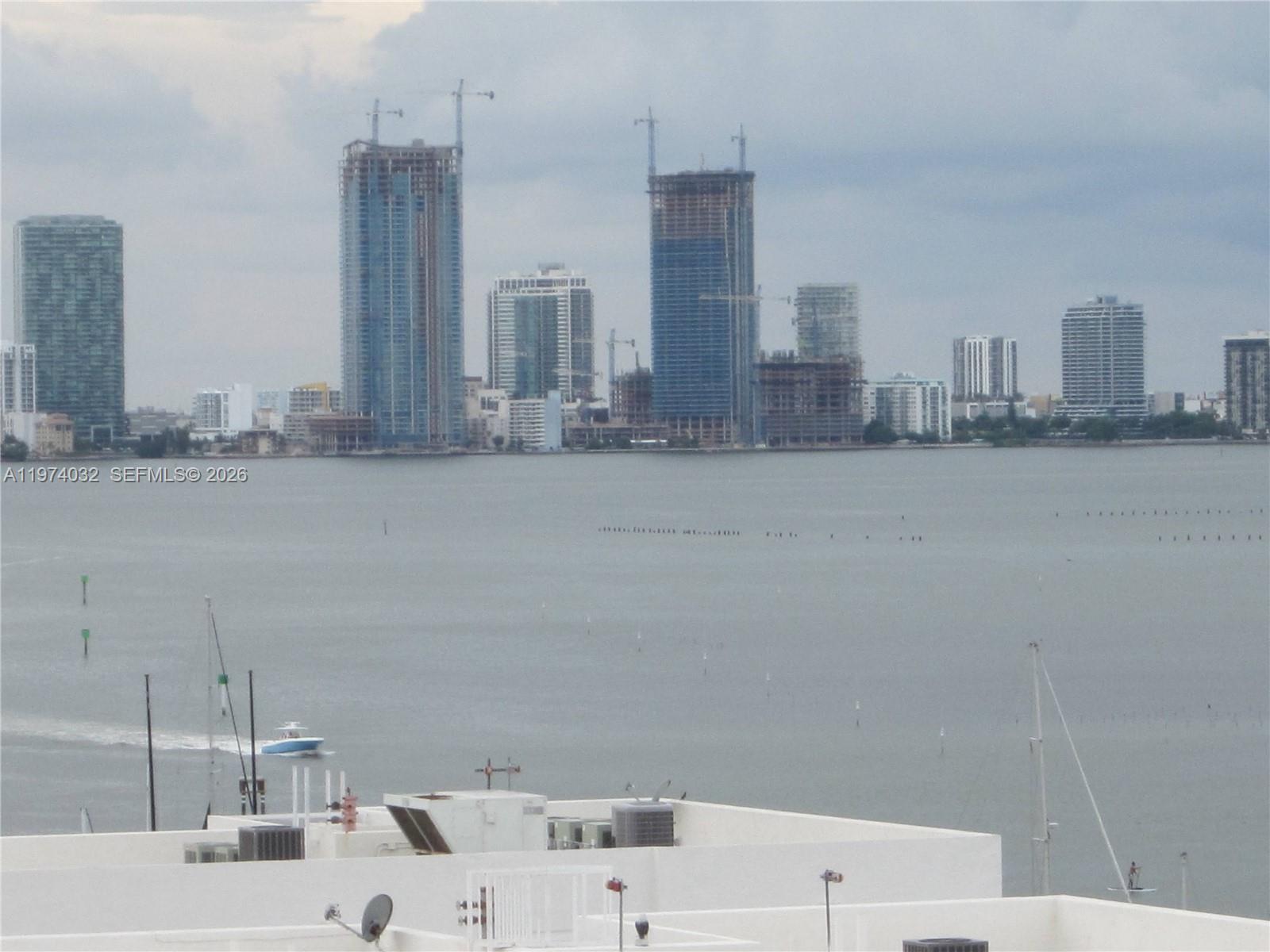 A view of a bay with boats and a distant city skyline under a cloudy sky — 1688 West Ave # 1107, Miami Beach FL 33139, MIAMI BEACH, FL