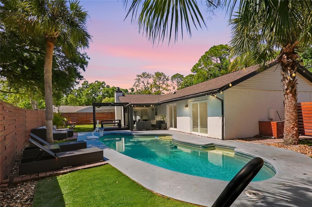 A backyard features a swimming pool, a patio with outdoor furniture, and a wooden fence — 4606 BUCKEYE ROAD, TAMPA, FL