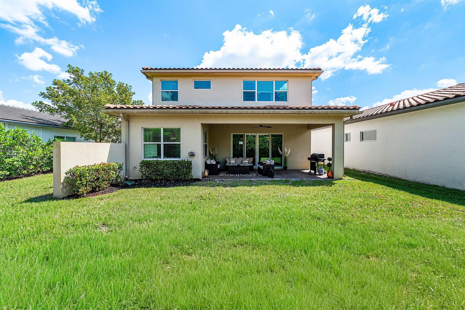 The exterior view shows the back of a two-story house with a covered patio — 4767 Marston Lane, Lake Worth FL 33467, LAKE WORTH, FL