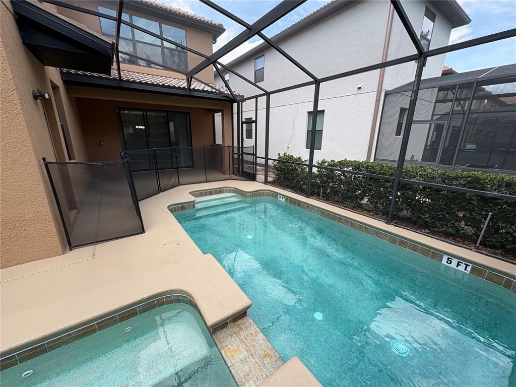 A screened-in patio features a rectangular swimming pool with an attached spa and concrete decking — 5408 SOLTERRA CIRCLE, DAVENPORT, FL
