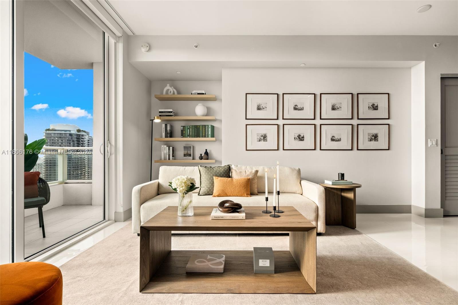 A living room features a beige sofa, wooden coffee table, wall shelving, and framed artwork — 1080 Brickell Ave # 3905, Miami FL 33131, MIAMI, FL