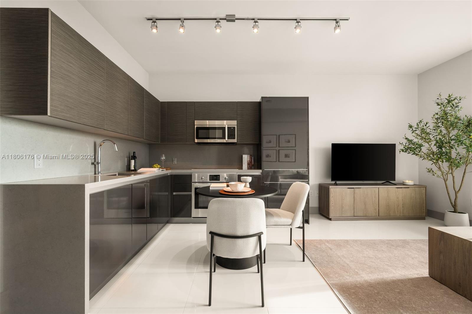 A modern kitchen features dark cabinetry, stainless steel appliances, and a small dining table — 1080 Brickell Ave # 3905, Miami FL 33131, MIAMI, FL