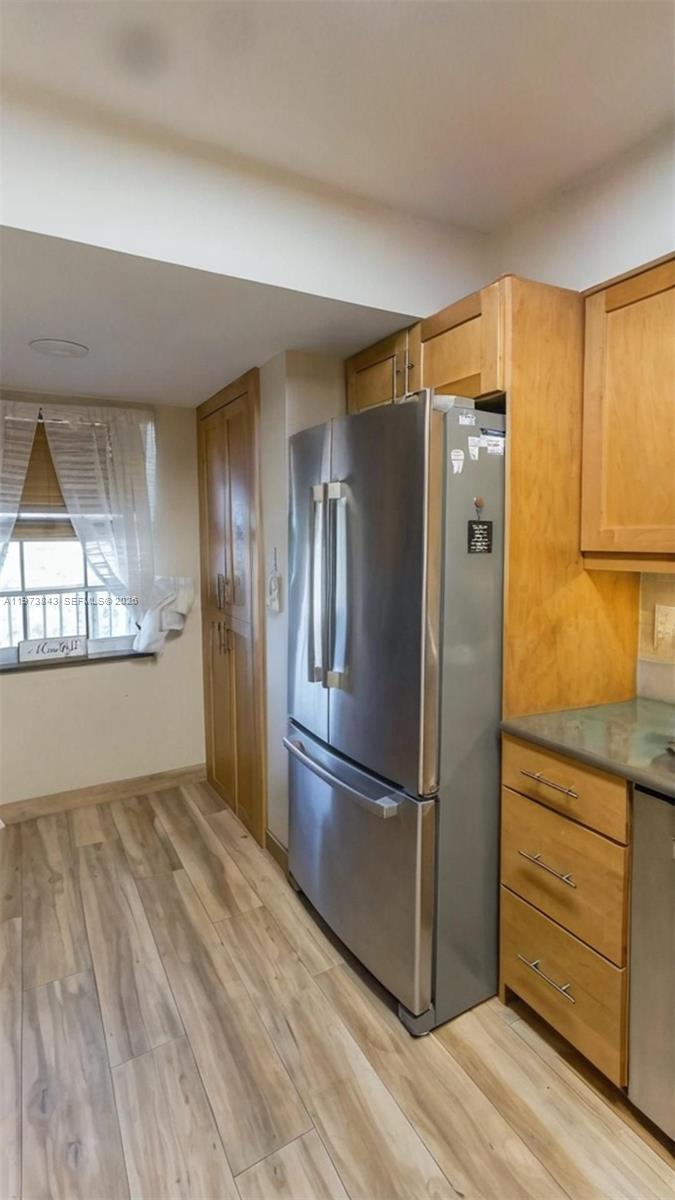 A living and dining area features light wood flooring, neutral walls, and modern furniture — 2900 N Course Dr # 804, Pompano Beach FL 33069, POMPANO BEACH, FL