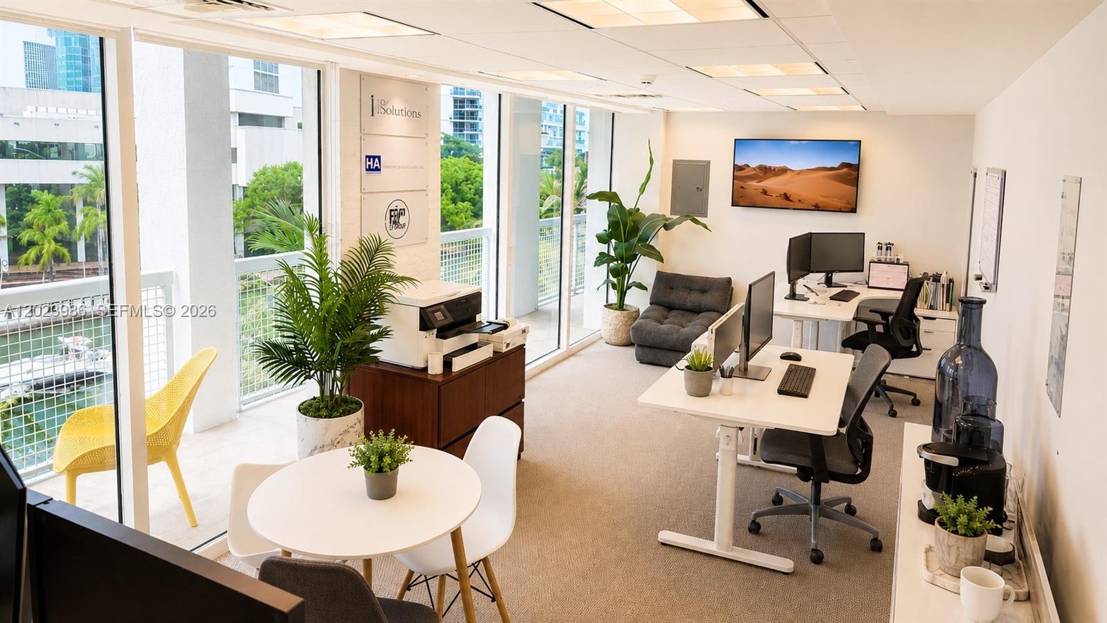 A modern office space features two desks, a small round table, and floor-to-ceiling windows — 31 SE 5th St # 502, Miami FL 33131, MIAMI, FL