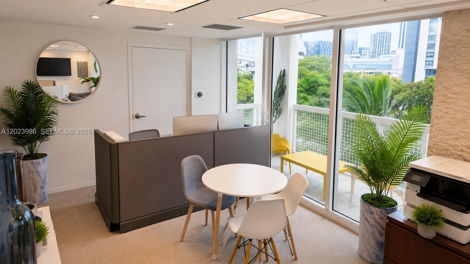 An office space features a desk partition, a small round table with chairs, and a balcony — 31 SE 5th St # 502, Miami FL 33131, MIAMI, FL