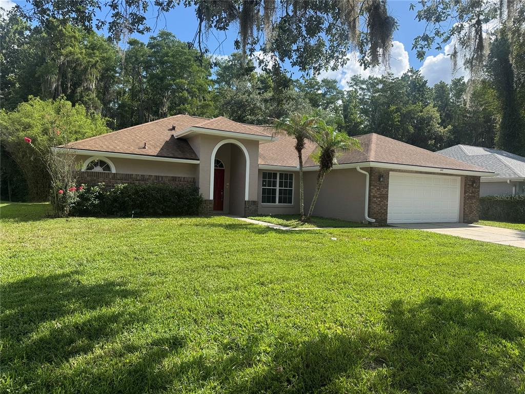 A single-story house with a brown roof, tan stucco exterior, and a two-car garage — 10941 MILL POND WAY, ORLANDO, FL