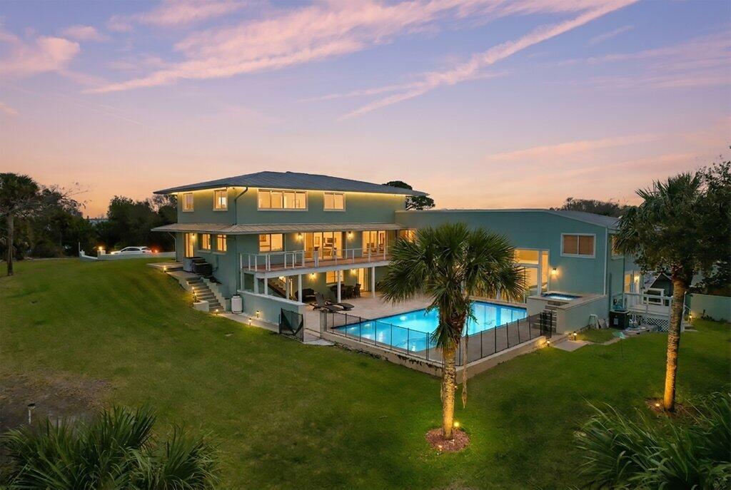 A two-story teal house with a swimming pool and patio at sunset — 3712 E Mockingbird Hill, Jensen Beach FL 34957, JENSEN BEACH, FL