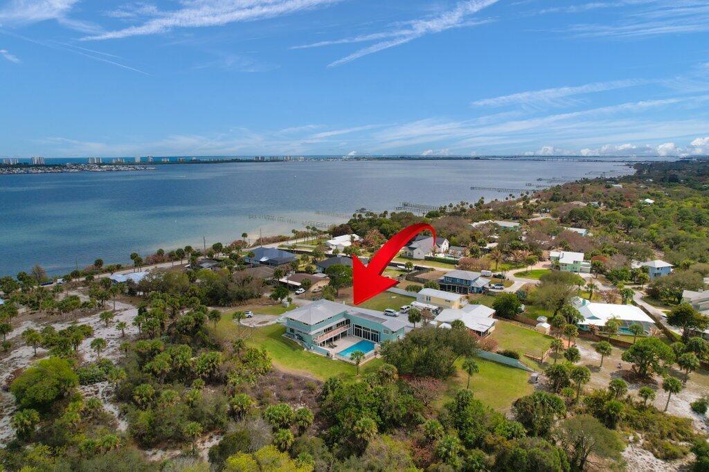 An aerial view shows a waterfront house with a swimming pool and a red arrow — 3712 E Mockingbird Hill, Jensen Beach FL 34957, JENSEN BEACH, FL