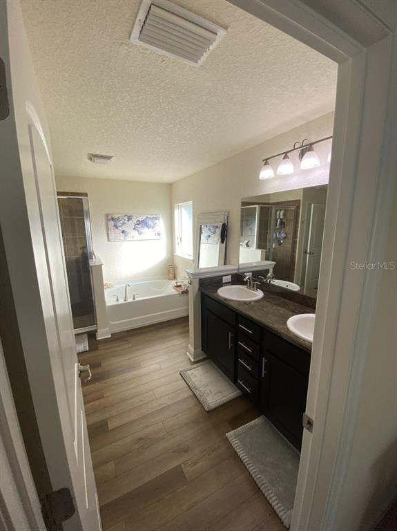 A bathroom features a double vanity with dark cabinets, a soaking tub, and a shower — 4634 SE 27TH STREET, OCALA, FL