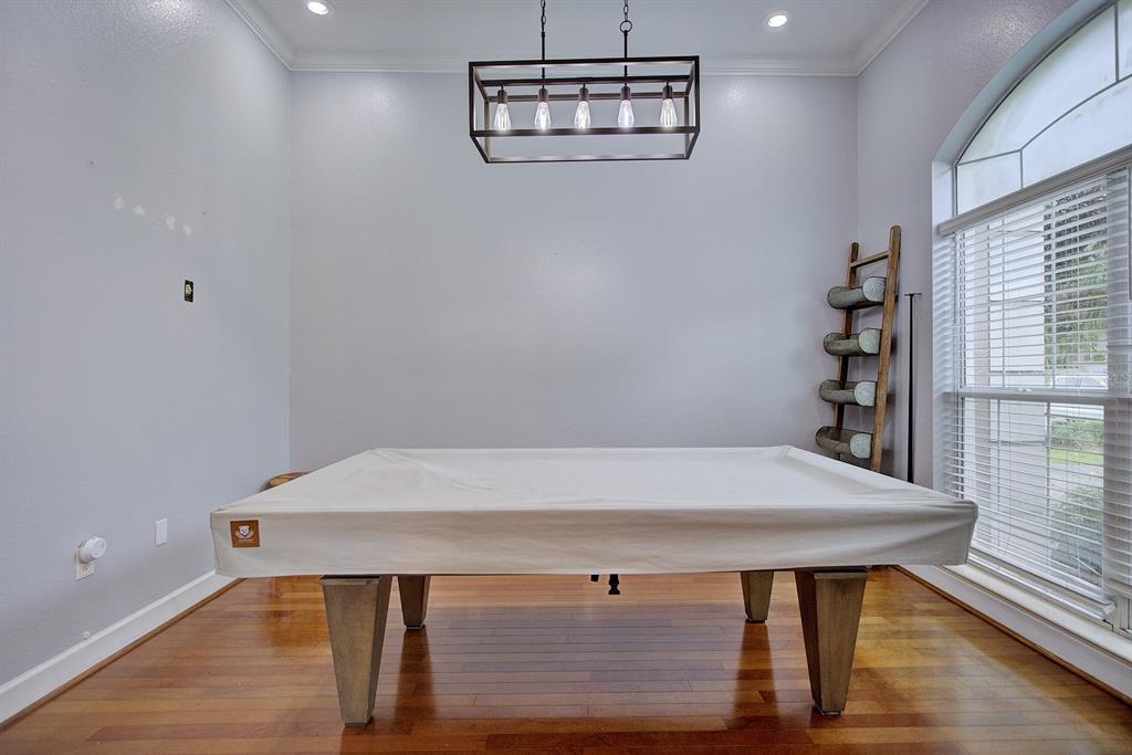 A pool table with a white cover sits in a room with hardwood floors — 188 HUNTLEY OAKS BOULEVARD, LAKE PLACID, FL