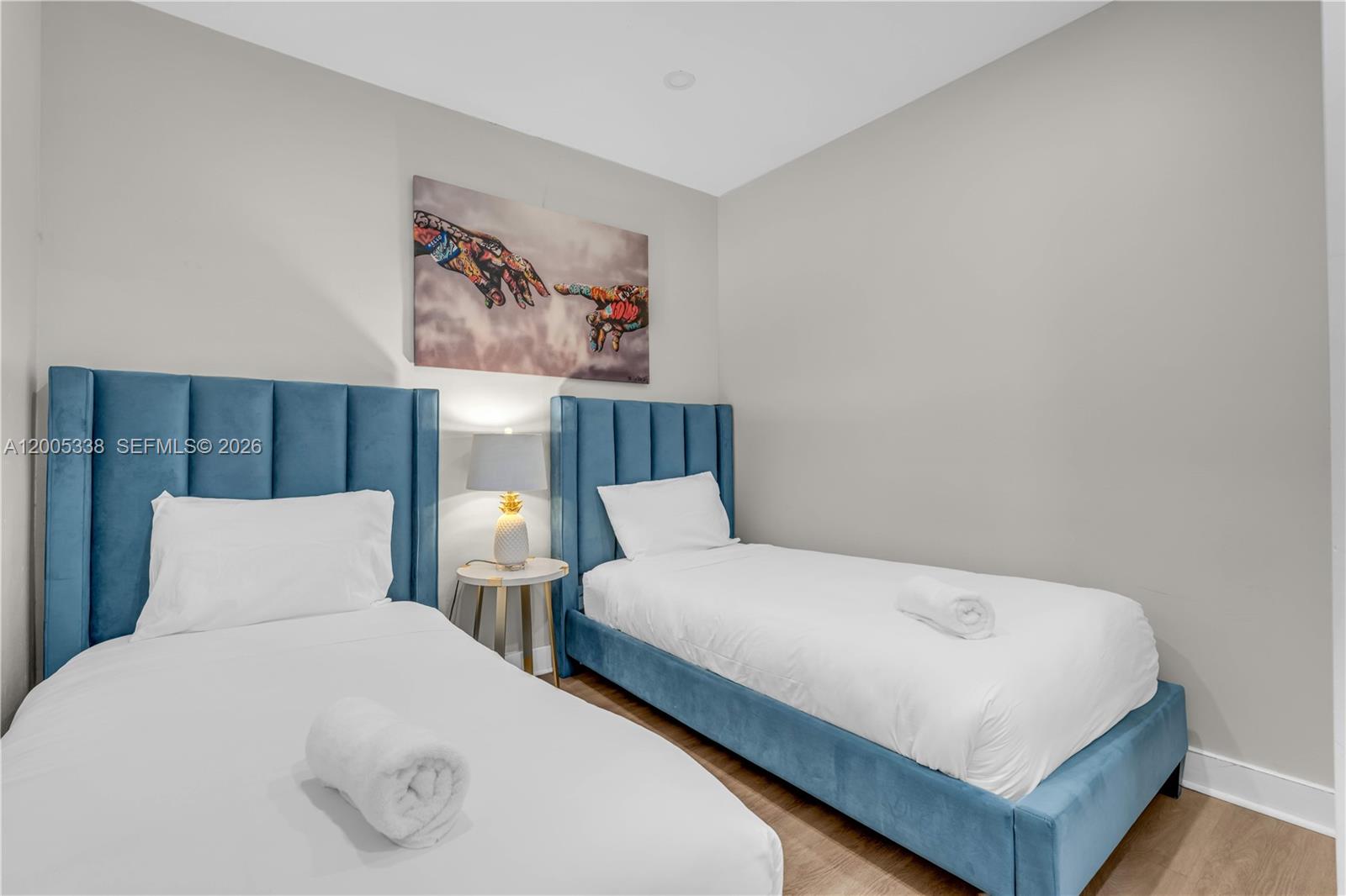A bedroom features two blue velvet twin beds with white bedding and a wall painting — 10006 E Bay Harbor Dr # 16, Bay Harbor Islands FL 33154, BAY HARBOR ISLANDS, FL
