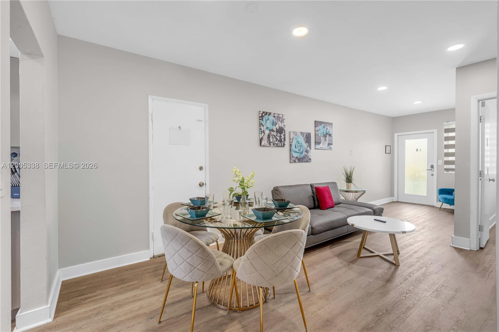 A dining area with a glass table and a living area with a grey sofa — 10006 E Bay Harbor Dr # 16, Bay Harbor Islands FL 33154, BAY HARBOR ISLANDS, FL
