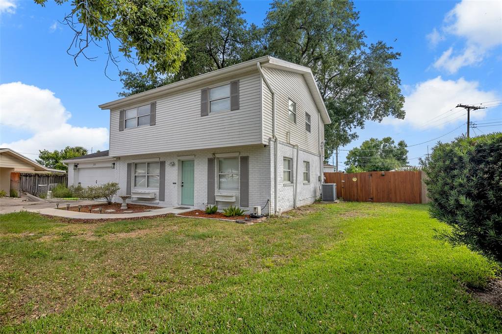 A two-story house with white siding and brick features a green front door and lawn — 215 KILMER LANE, WINTER HAVEN, FL