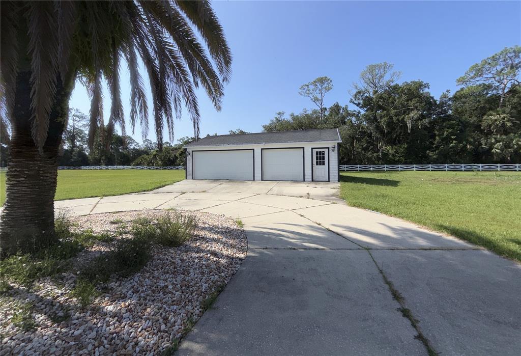 A white brick house with a large driveway, a basketball hoop, and a prominent oak tree — 2015 HALIFAX DRIVE, PORT ORANGE, FL
