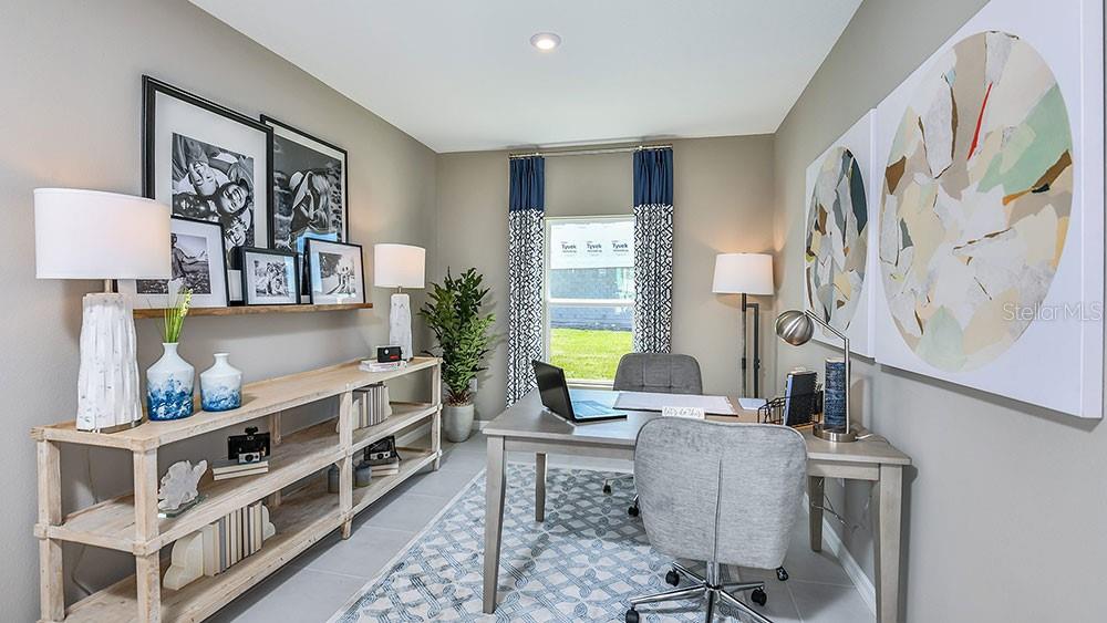 A home office features a wooden desk, a matching shelving unit, and patterned curtains — 12219 TEMPEST LANE, HUDSON, FL
