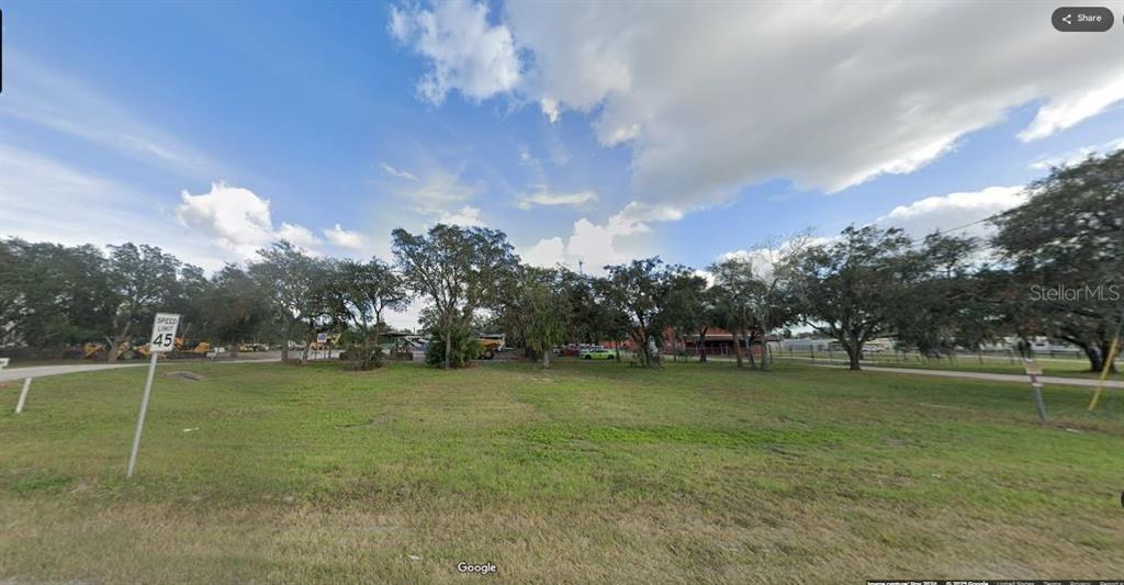A grassy, vacant lot with scattered trees and a speed limit sign under a cloudy sky — N/A, POLK CITY, FL