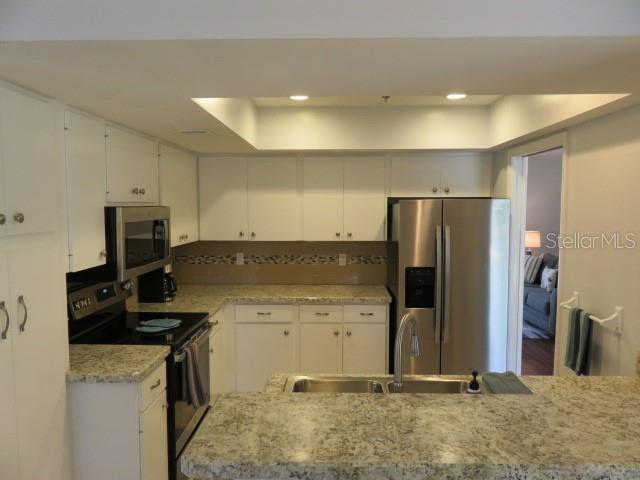 A kitchen with white cabinets, granite countertops, stainless steel appliances, and a breakfast bar — 7207 15TH AVENUE DRIVE W, BRADENTON, FL