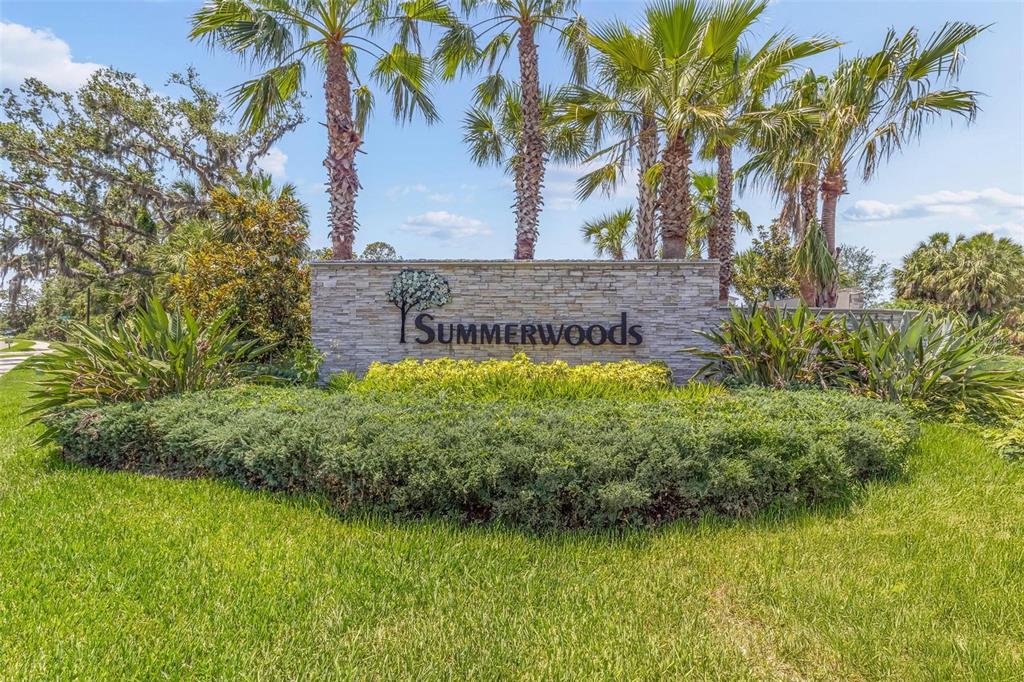 A stone monument sign for Summerwoods stands surrounded by palm trees and landscaping — 10945 HIGH NOON TRAIL, PARRISH, FL