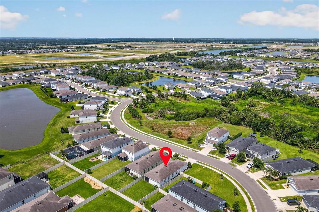 An aerial view shows a suburban neighborhood with a red pin marking a specific house — 10945 HIGH NOON TRAIL, PARRISH, FL