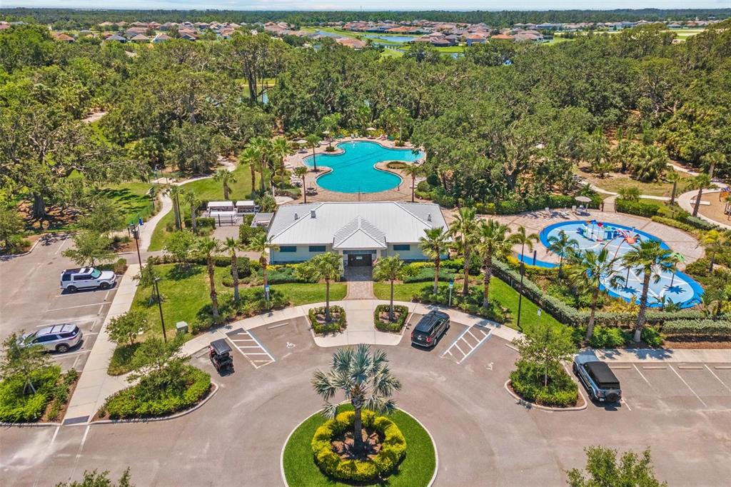 An aerial view shows a community clubhouse with a swimming pool and a splash pad — 10945 HIGH NOON TRAIL, PARRISH, FL