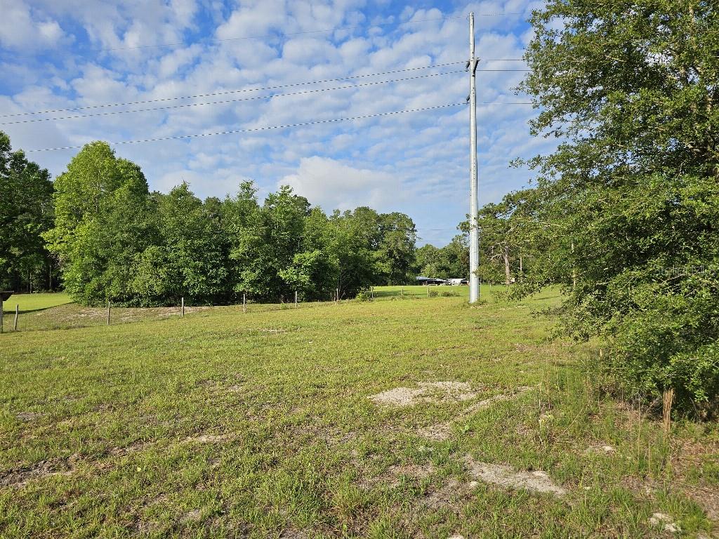 A large, grassy field features a utility pole and a line of trees in the background — 0 SW SPIRIT AVE AVENUE, FORT WHITE, FL
