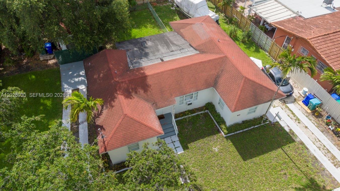 An aerial view shows a single-story house with a red shingled roof and flat section — MIAMI, FL